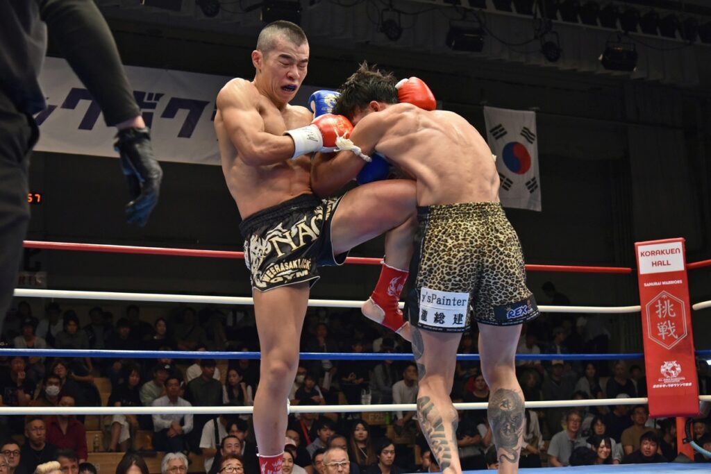 NAOKIのヒザ蹴りがヒット。ボディー攻めが勝利を導いた